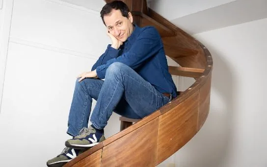 Le physicien Julien Bobroff, assis dans un escalier en colimaçon.